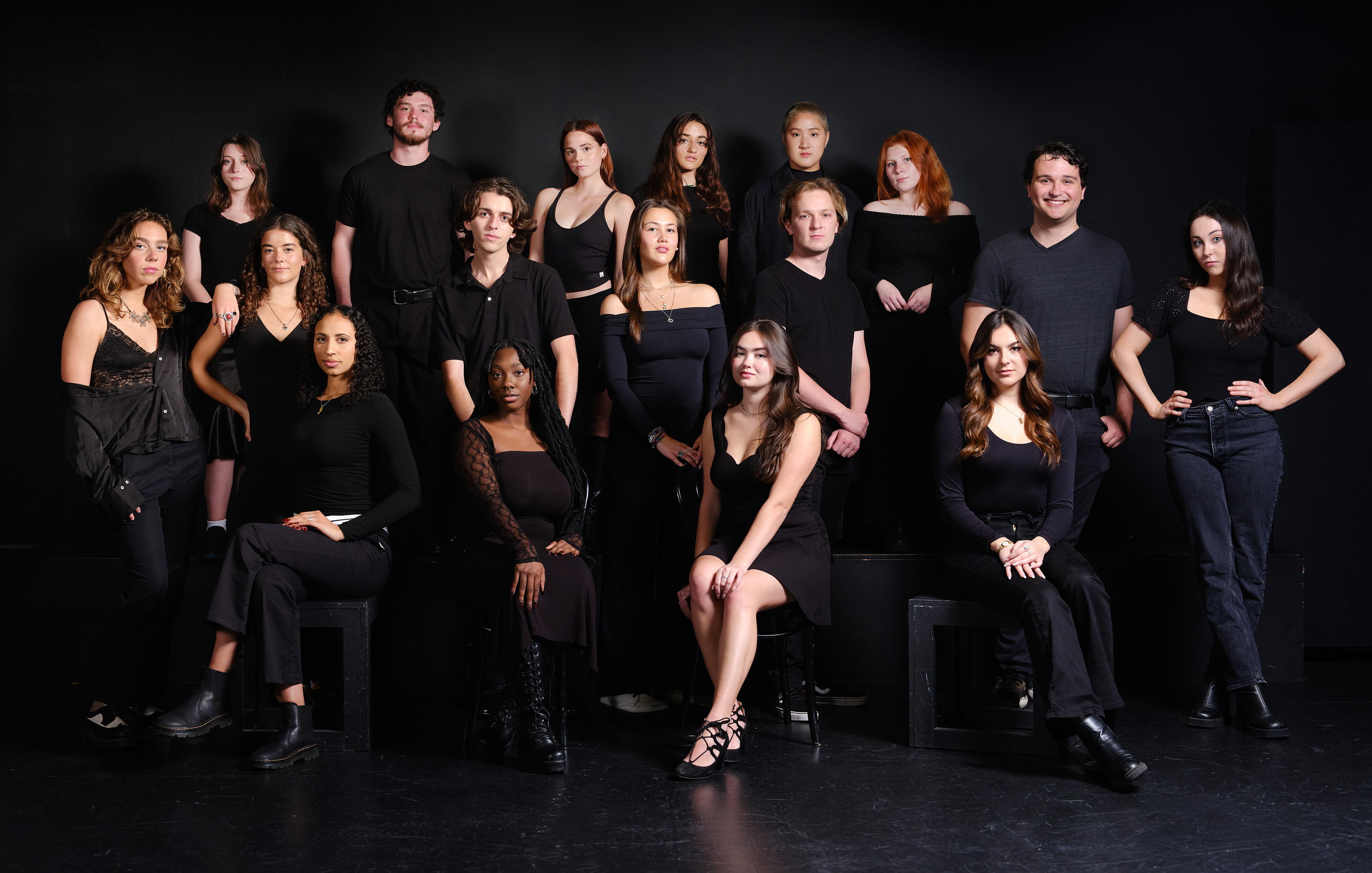 a group of men and women dressed in all black posing.